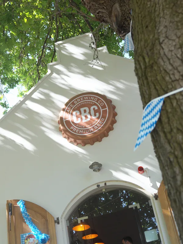 The CBC gable under the oaks, dressed in Bavarian blue