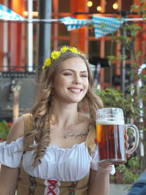 A hostess in a dirndl with a stein of CBC