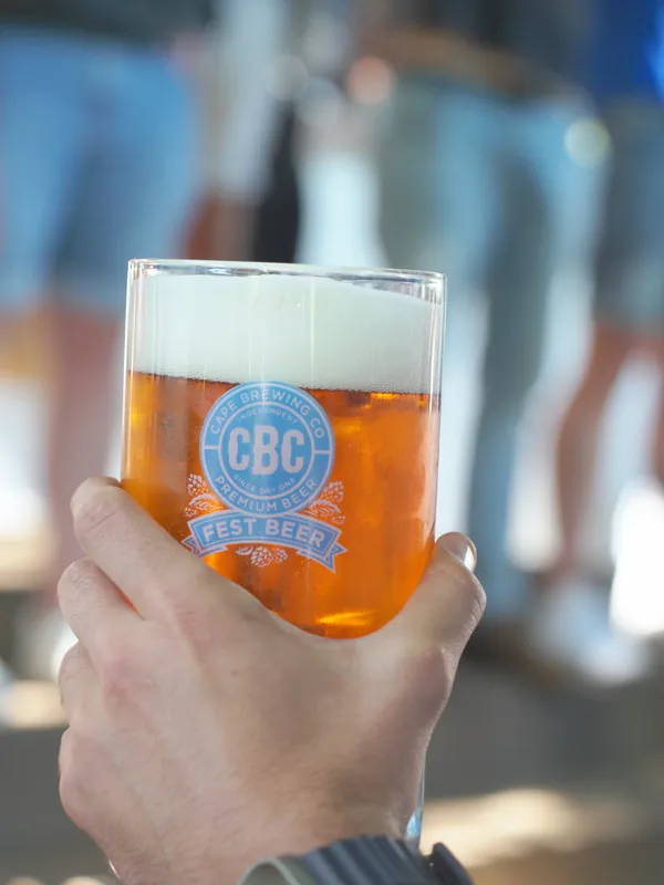 A hand holding a CBC Oktoberfest glass